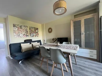 a dining room with a table and a blue couch at Apartamento da Fraga in Arzúa