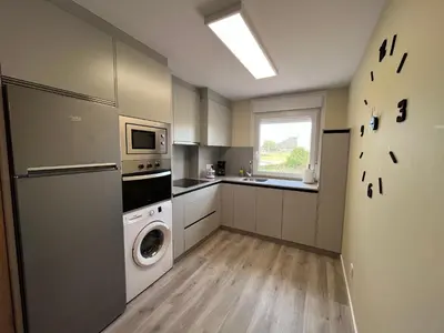 a kitchen with a washing machine and a washer at Apartamento da Fraga in Arzúa