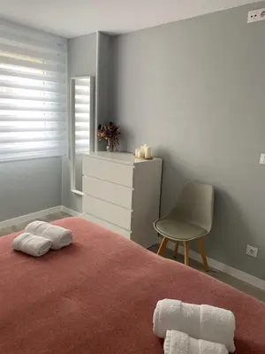 a bedroom with a bed with a chair and a dresser at Apartamento da Fraga in Arzúa