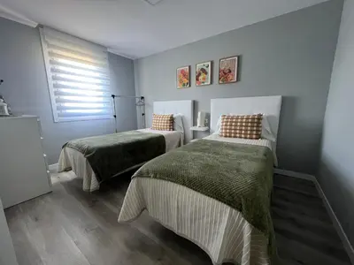 a bedroom with two beds and a window at Apartamento da Fraga in Arzúa