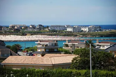 a view of a beach with buildings and the ocean at Ático con vistas a la ría y a Foz in Barreiros