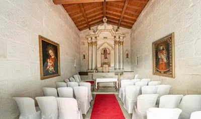 a room with white chairs and a altar with a red carpet at Casa Rural Pazo San Damian in Amoeiro