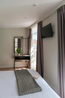 a bedroom with a bed with a television on the wall at Albatros in Puentedeume