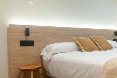 a bedroom with a large bed with a wooden headboard at Albatros in Puentedeume