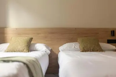 two beds sitting next to each other in a bedroom at Albatros in Puentedeume