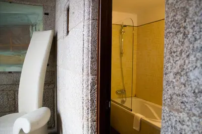 a bathroom with a tub and a toilet and a shower at Hotel A Tafona do Peregrino in Santiago de Compostela