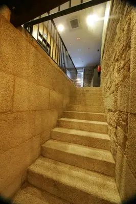 a staircase in a building with a stone wall at Hotel A Tafona do Peregrino in Santiago de Compostela