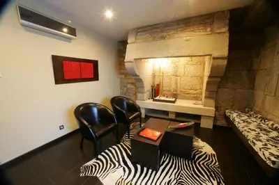 a room with a table and chairs and a fireplace at Hotel A Tafona do Peregrino in Santiago de Compostela
