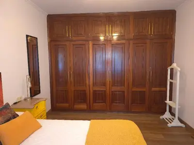 a bedroom with a large wooden closet with a bed at Apartamento Alecrin Padrón in Padrón