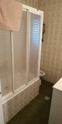 a bathroom with a shower with a window and a toilet at EnFOZ CONFORT Y RELAX in Foz