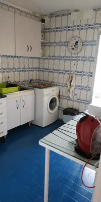 a kitchen with a washing machine and a table at EnFOZ CONFORT Y RELAX in Foz