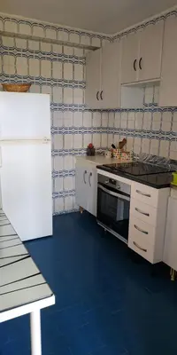 a kitchen with white appliances and a blue floor at EnFOZ CONFORT Y RELAX in Foz