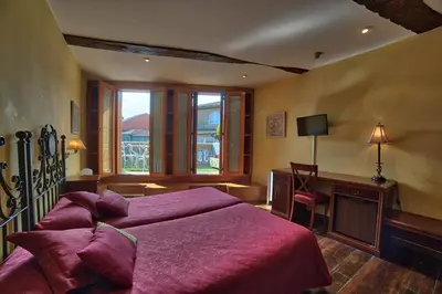 a bedroom with a large purple bed and a desk at Hostal Santo Grial in Santiago de Compostela