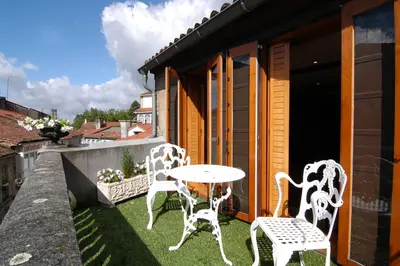 two white chairs and a table on a balcony at Hostal Santo Grial in Santiago de Compostela