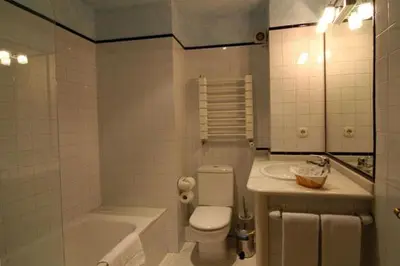 a bathroom with a toilet and a tub and a sink at Hostal Santo Grial in Santiago de Compostela
