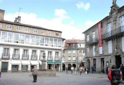 a group of people walking around in a city at Hostal Santo Grial in Santiago de Compostela