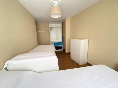 a bedroom with two beds and a dresser in it at Río, mar y montaña in Puentedeume