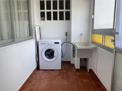 a small bathroom with a washing machine and a sink at Río, mar y montaña in Puentedeume