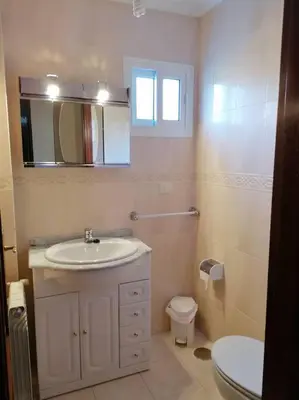 a bathroom with a sink and a toilet and a mirror at O Lar do Suso in Refojos