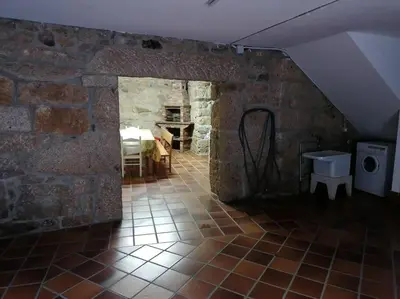 a room with a stone wall and a room with a table at O Lar do Suso in Refojos