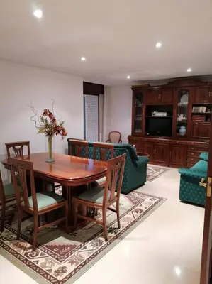 a living room with a wooden table and chairs at O Lar do Suso in Refojos