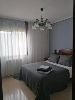 a bedroom with a bed and a chandelier at O Lar do Suso in Refojos
