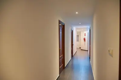 a hallway with white walls and tile floors at Hostal Molgas in A Medorra