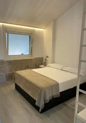 a bedroom with a bed with a ladder and a window at Cepas Da Cuenga in Ribadavia