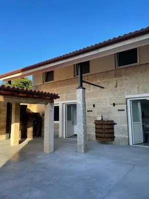 a large brick building with two columns and a patio at Cepas Da Cuenga in Ribadavia