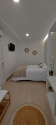 a white bedroom with a bed and a mirror at A CASIÑA DE ISABEL in Arzúa
