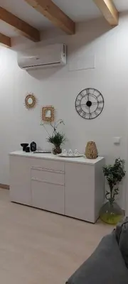 a white kitchen with a counter and a clock on the wall at A CASIÑA DE ISABEL in Arzúa