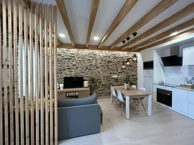 a kitchen and dining room with a stone wall at A CASIÑA DE ISABEL in Arzúa