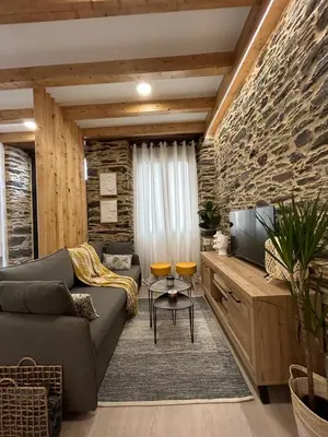 a living room with a couch and a tv at A CASIÑA DE ISABEL in Arzúa