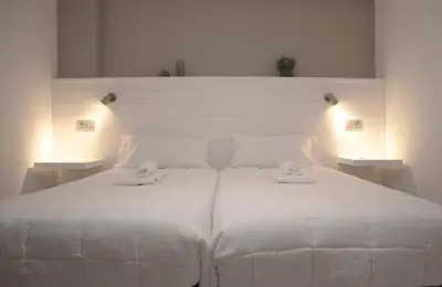 a white bed with two white towels on it at Apartamento en Sigüeiro Rúa do Tambre in Sigüeiro