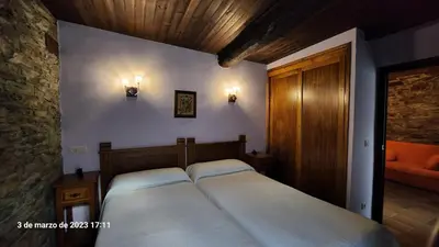 a bedroom with a bed with two white pillows at Apartamentos Rurales Casa Ardaliz in Cangas del Narcea