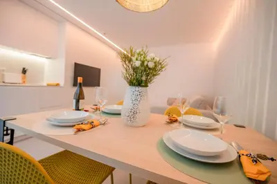 a dining room table with plates and a vase of flowers at Apartamentos Atia Catedral in Santiago de Compostela