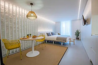 a room with a table and chairs and a bed at Apartamentos Atia Catedral in Santiago de Compostela