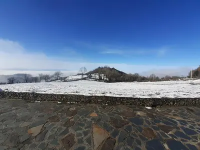 a snow covered field with a stone wall at O Busto Aldea Rural, Apartamento HORNO 1 in Puebla del Brollón