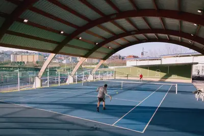 a man playing tennis on a tennis court at Súper apartamento Santiago in Santiago de Compostela