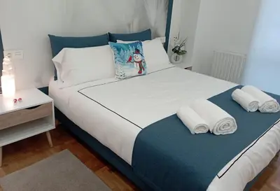 a bedroom with a large bed with towels on it at Súper apartamento Santiago in Santiago de Compostela