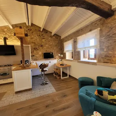 a living room with a blue couch and a kitchen at Casa de Casal in Lestedo