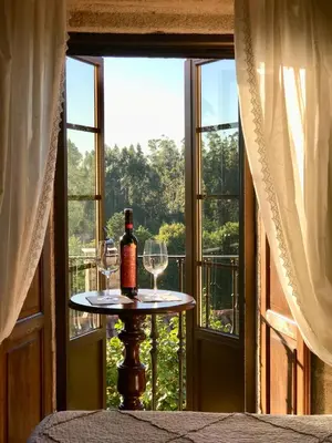 a table with glasses and a bottle of wine in front of a window at Casa de Casal in Lestedo