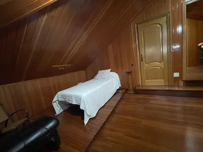 a small bedroom with a bed in a wooden room at Impresionante casa con parcela en la naturaleza in A Coruña