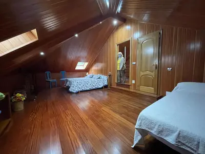 a man is standing in a room with a bed at Impresionante casa con parcela en la naturaleza in A Coruña