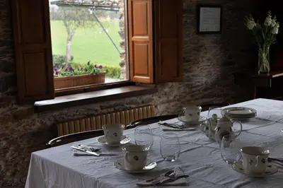a table in a restaurant with a white table cloth at Casa A Curiscada in Burres
