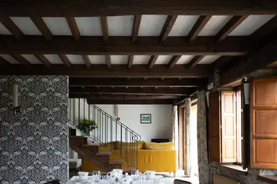 a dining room with a staircase and a yellow couch at Casa A Curiscada in Burres