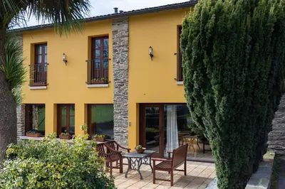 a yellow house with a table and chairs in front of it at Casa A Curiscada in Burres