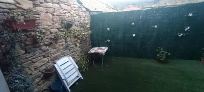 a white chair sitting in a yard next to a stone wall at Casa Ángel in Barreiros