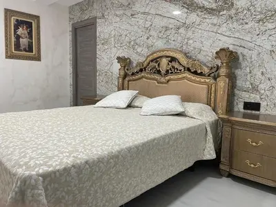 a bedroom with a large bed and a stone wall at Luxury Barco de Valdeorras in Vegamolinos