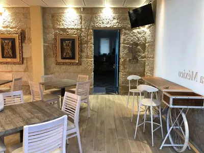 a restaurant with wooden tables and white chairs at Hotel Villa México in Faramentaos